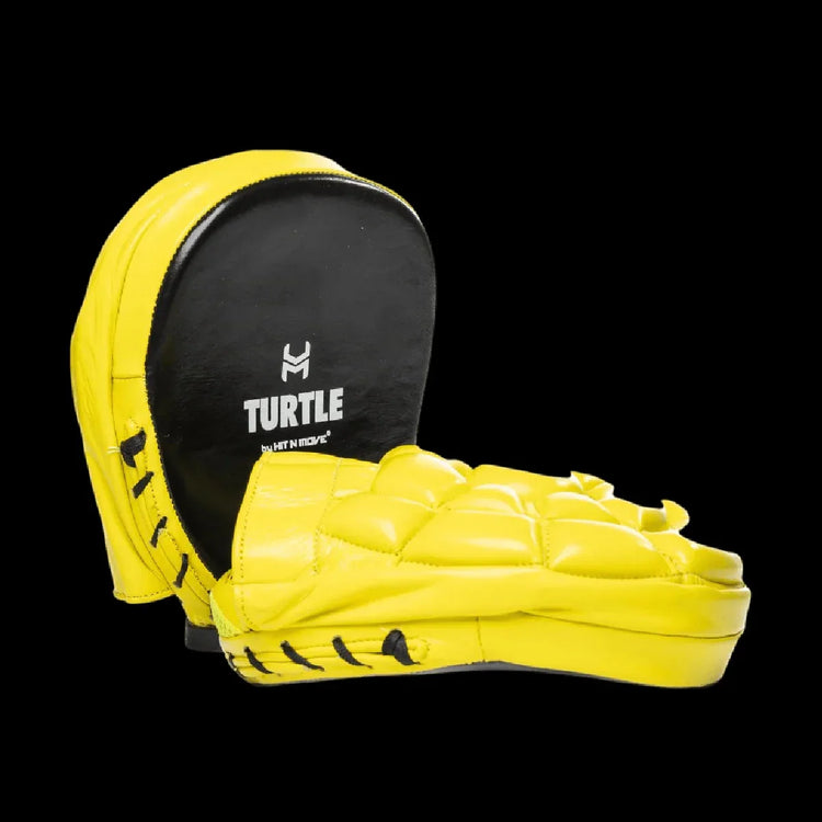 Yellow and black Turtle brand boxing focus mitts with padded surface on black background