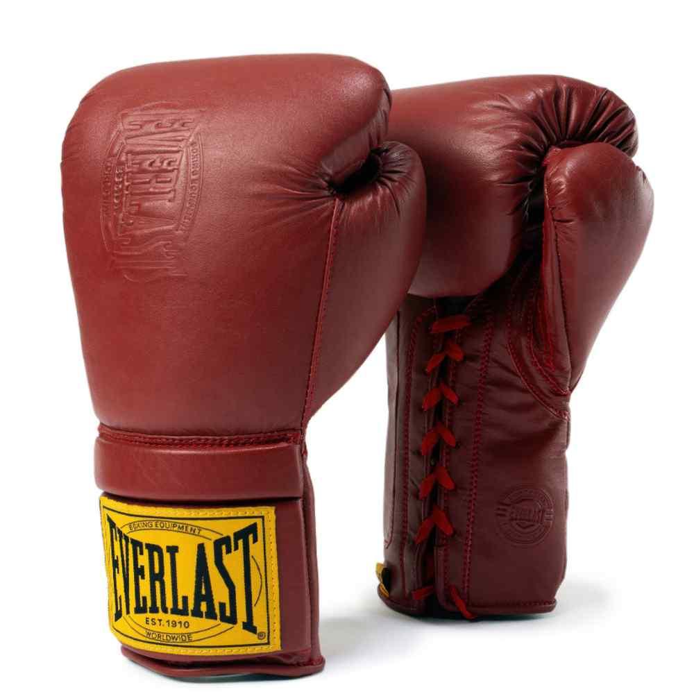 Red lace-up professional boxing gloves with yellow logo patch on wrist, isolated on white