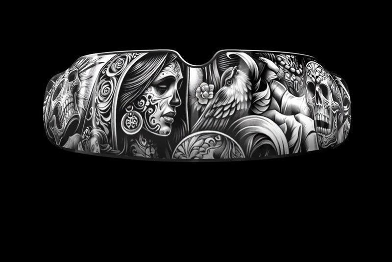 Boxing mouthguard with detailed black and white skull, woman, bird, and floral tattoo art