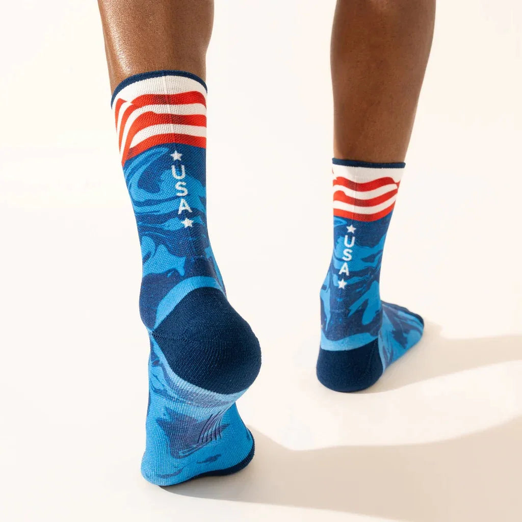 Blue athletic socks with USA text and American flag design worn on feet