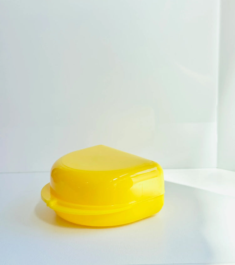 Yellow boxing mouthguard case on white background