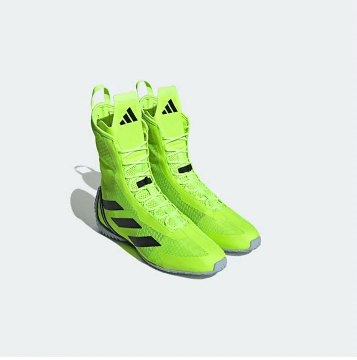 Neon green high-top boxing shoes with black accents and mesh design on light background.