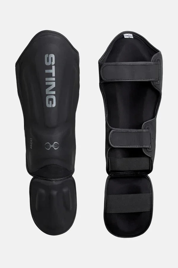 Black MMA shin and foot protectors with Velcro straps and STING logo, side by side