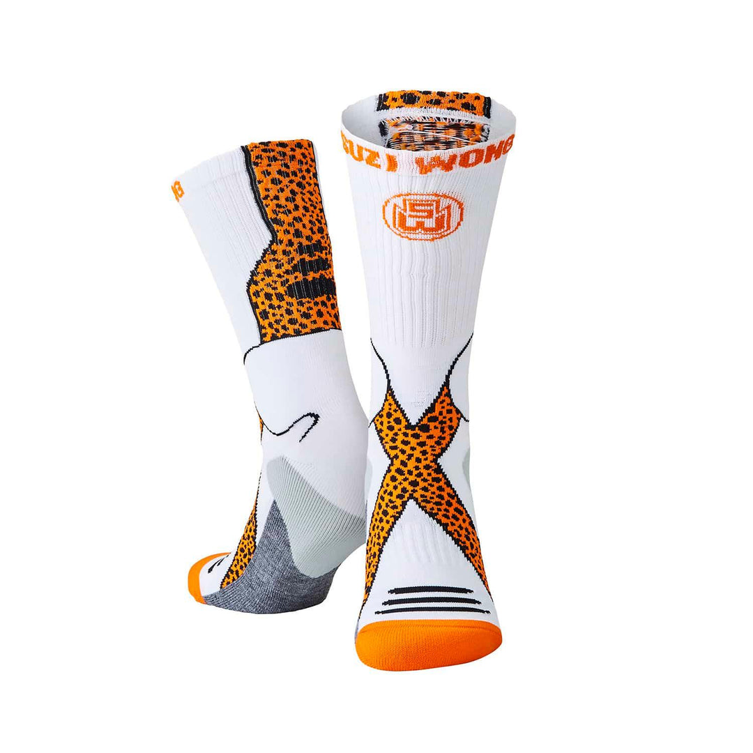 White athletic socks featuring orange cheetah print design, sports performance crew socks
