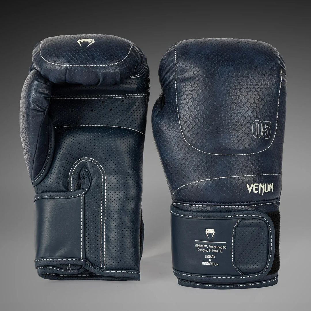 Dark blue Venum boxing gloves with textured leather, white stitching, and wrist strap