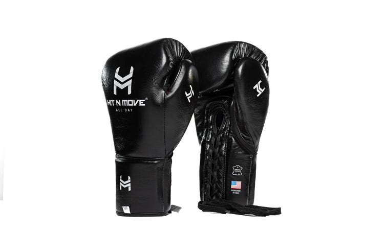 Black leather boxing gloves with lace-up design and printed white logos on a white background.