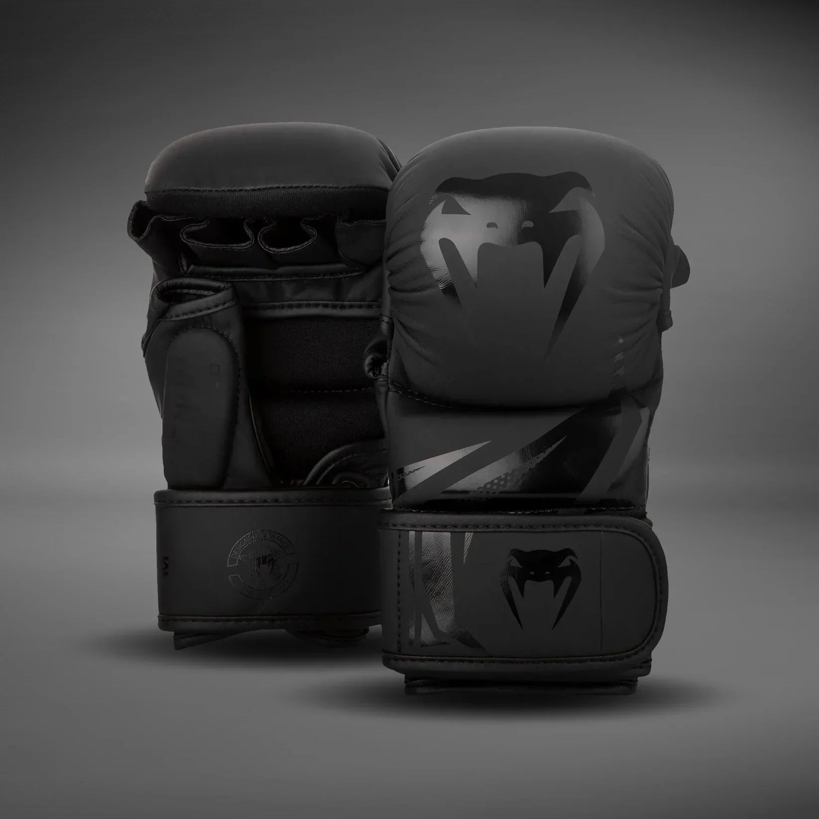 Black boxing gloves with glossy snake logo on a neutral background, premium training gear