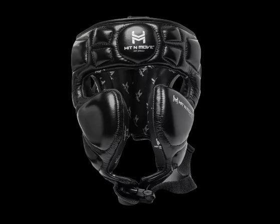 Black leather boxing headgear with face protection, featuring HIT N MOVE logo on front, isolated on black background.