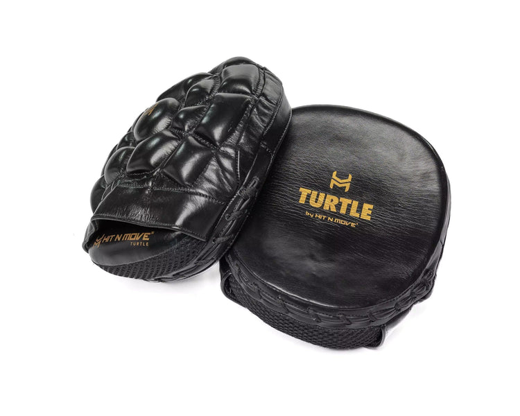 Black leather boxing focus pads with 'TURTLE by HIT N MOVE' gold logo on white background.