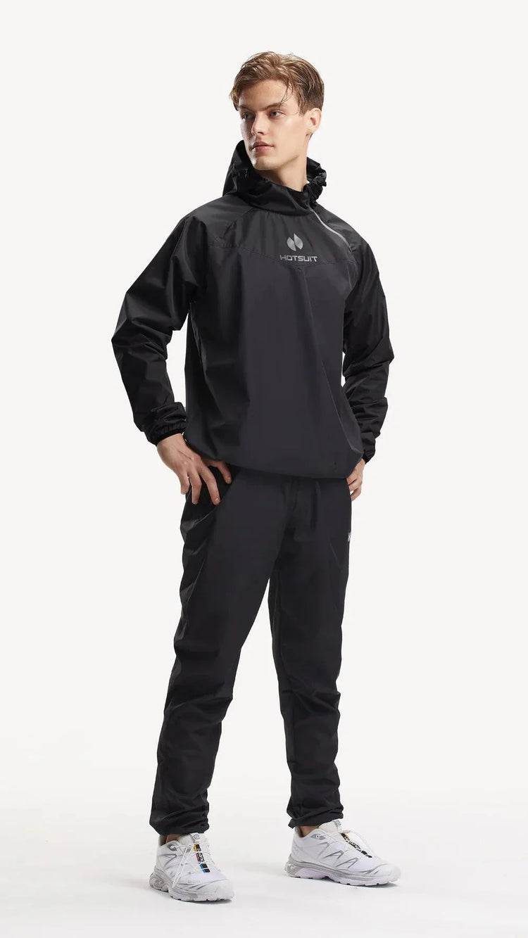 Man wearing black long sleeve sauna suit with hood, elastic cuffs, and athletic white shoes