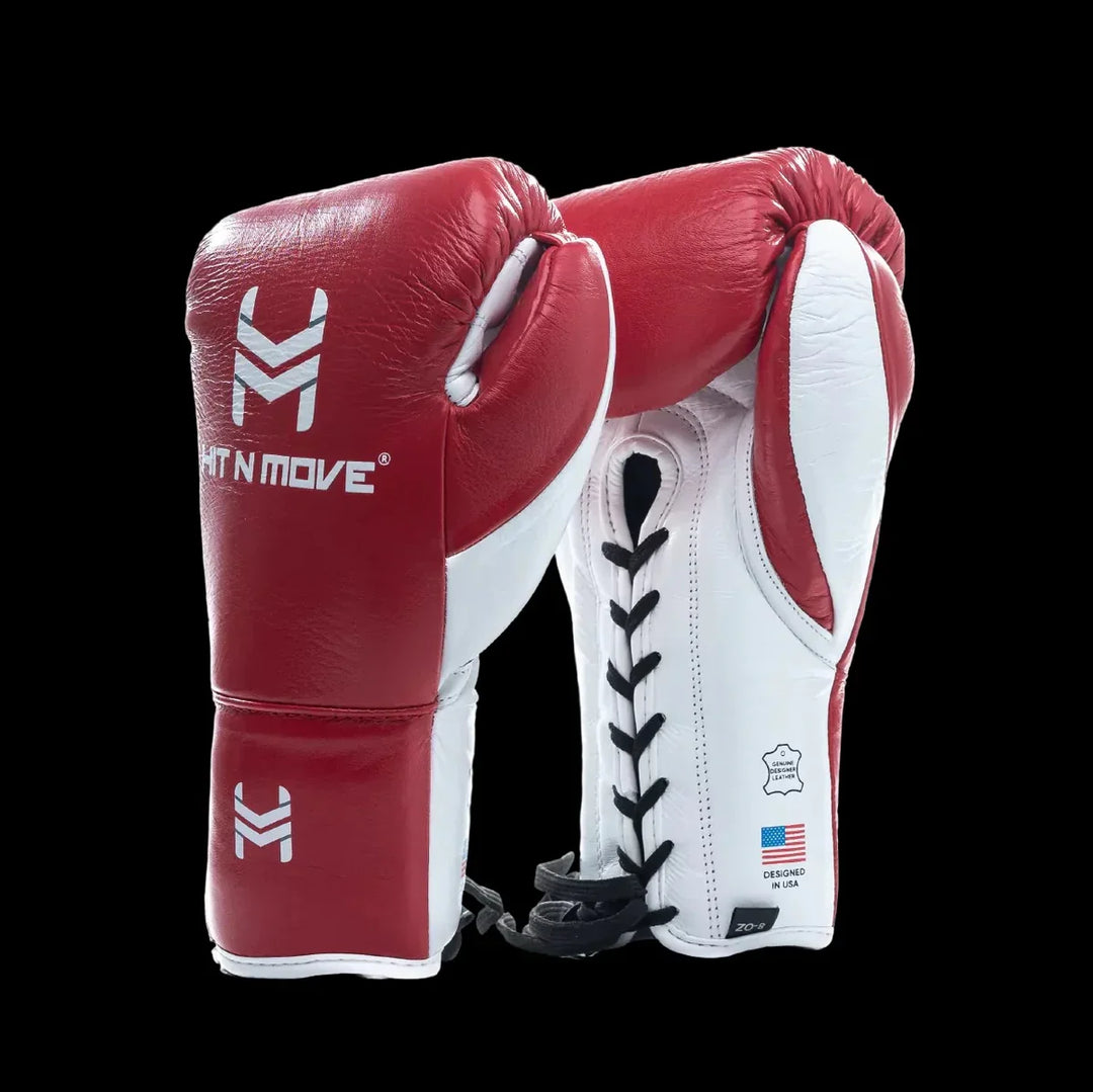 Red and white lace-up leather boxing gloves with branding on black background