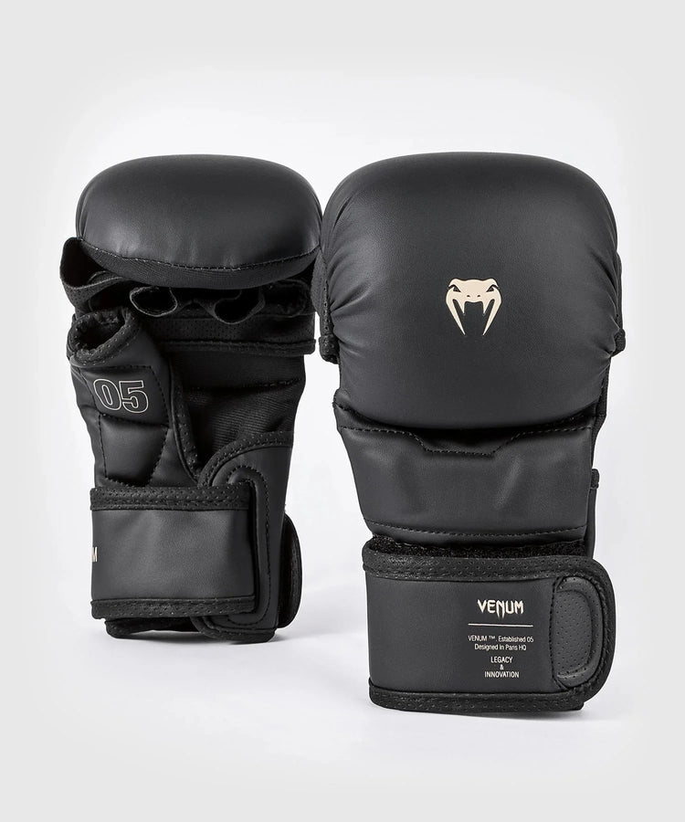 Black MMA sparring gloves with open palm design and Venum logo on wrist strap